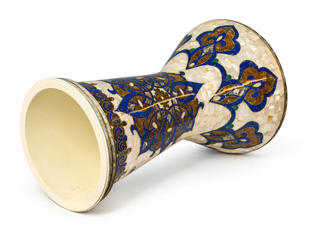 Sala Azure Arabesque Sombaty darbuka on its side, showing the open base and cobalt-blue and gold-toned floral mosaic on an ivory background.