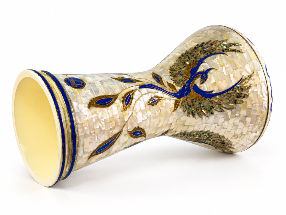 Sala Phoenix Pearl Sombaty darbuka on its side, showing the open base and a sweeping blue-and-gold bird motif on pale mosaic.